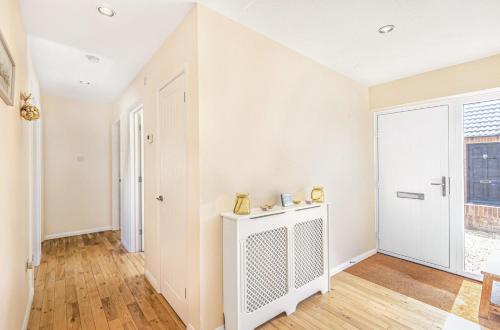 a living room with white walls and a wooden floor at Pinellas Point in East Wittering