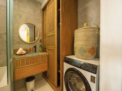 a laundry room with a washing machine and a mirror at TA Danang Boutique Hotel in Da Nang