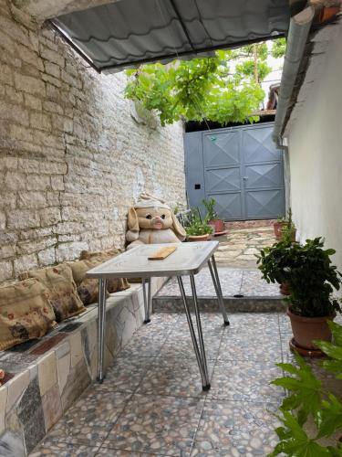 una mesa con un osito de peluche sentado en un patio en Marko's House en Gjirokastër