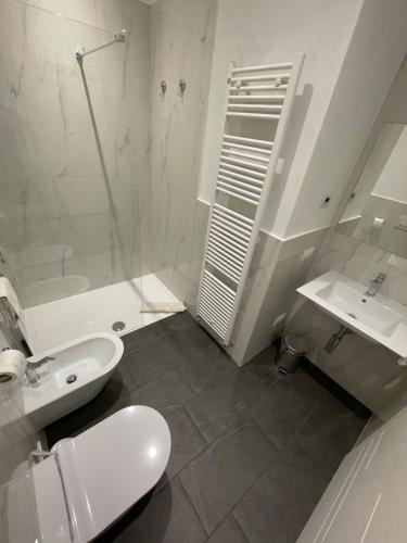 a white bathroom with a toilet and a sink at Appartamento Riviera in Cremia
