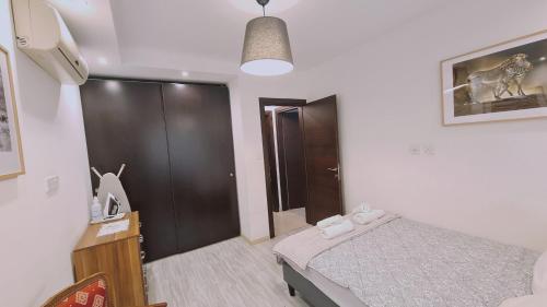 a small bedroom with a bed and a black closet at STAY Serenity Apartment in Yukarı Lakatamya