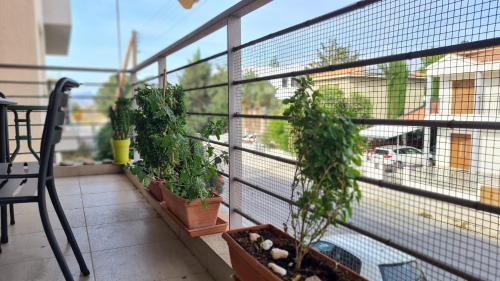 a balcony with plants and a chair and a window at STAY Serenity Apartment in Yukarı Lakatamya