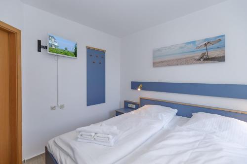 キュールングスボルンにあるYachthafenresidenz-Wohnung-5103-807のベッドルーム1室(ベッド1台、タオル2枚付)