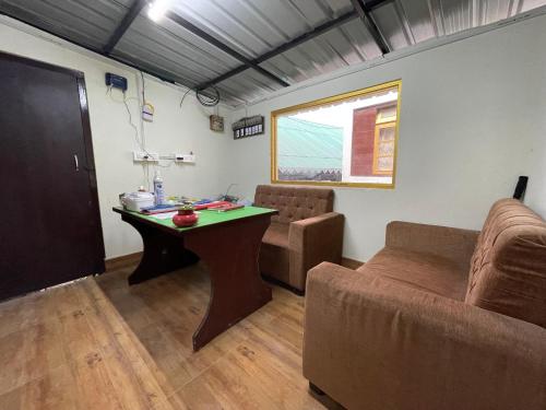 a living room with a table and a couch at Apple Valley Cottages Lachung in Lachung