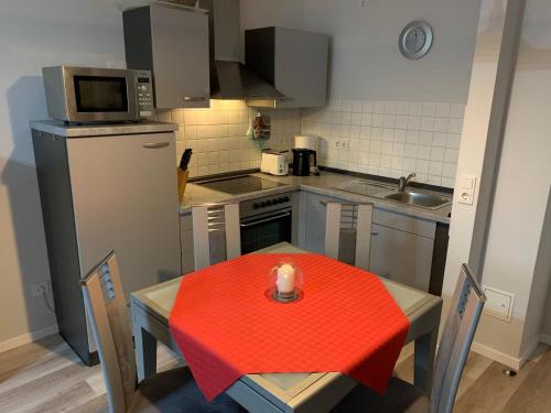 キュールングスボルンにあるResidenz-Ostseestrand-WE-20-9948の小さなキッチン(赤いテーブル、キャンドル付)