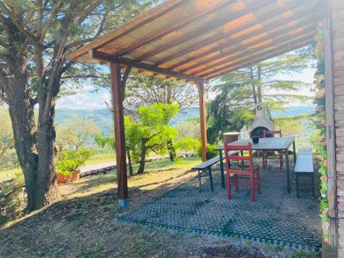 a table and chairs under a wooden pergola at Locazione turistica ex Le Casette Di Cedromonte in Panicale