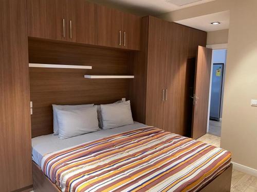 een slaapkamer met een bed met een houten muur bij Silver-bell Apartments in Accra
