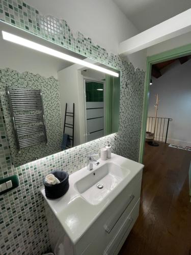 een badkamer met een witte wastafel en een spiegel bij Appartamento incantevole sull'antica via Lauretana in Loreto