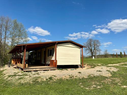 a small house sitting in a field of grass at Domek Holenderski Podlasie in Sejny