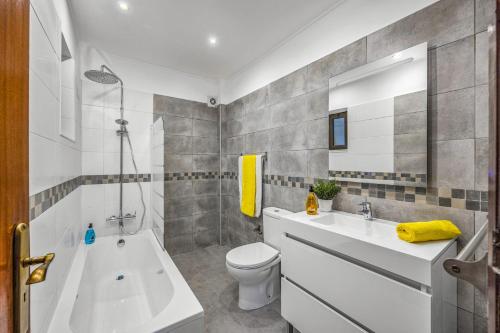 La salle de bains est pourvue d'une baignoire, de toilettes et d'un lavabo. dans l'établissement Villa Laranja do Sul by Villa Plus, à Carvoeiro