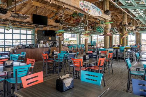 a dining room with tables and colorful chairs at The Pensacola Beach Resort in Pensacola Beach