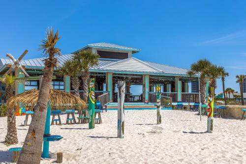 a resort on the beach with palm trees in the sand at The Pensacola Beach Resort in Pensacola Beach