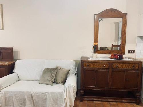 a living room with a white couch and a mirror at Locazione turistica ex Le Casette Di Cedromonte in Panicale