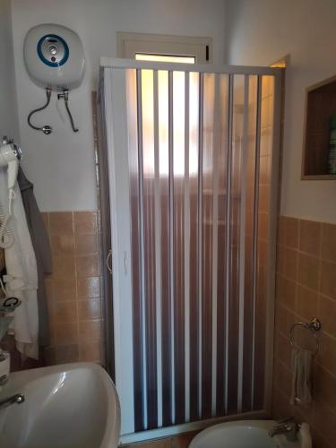 a bathroom with a shower and a toilet and a sink at Giardino dei Baroni house in Marina di Mancaversa