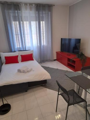 a bedroom with a bed and a tv and a table at Holiday Properties Trieste San Francesco in Trieste