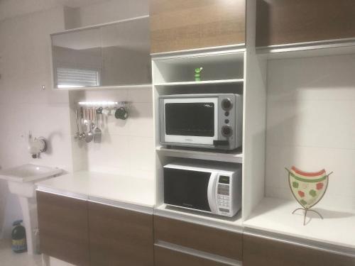 a microwave oven sitting on top of a kitchen counter at Studio Residencial Montevideo in Osório