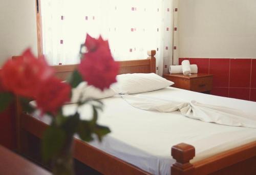 a bedroom with a bed with red flowers on it at Urban Apartments in Ulcinj