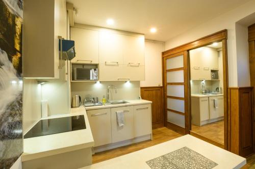 a kitchen with white cabinets and a sink at Apartament Oskar in Karpacz