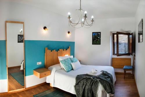 Schlafzimmer mit einem Bett und einem Kronleuchter in der Unterkunft Fogar do Pumar in Pantón