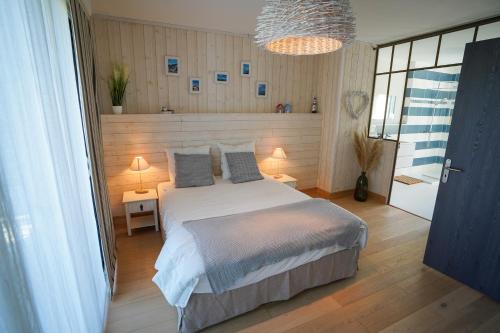 a bedroom with a large bed with two pillows at La Casita - Ronce les bains in La Tremblade
