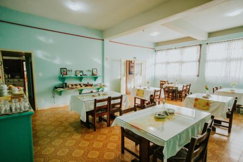 una sala da pranzo con tavoli e sedie di Pousada Casa da Paz a Gramado