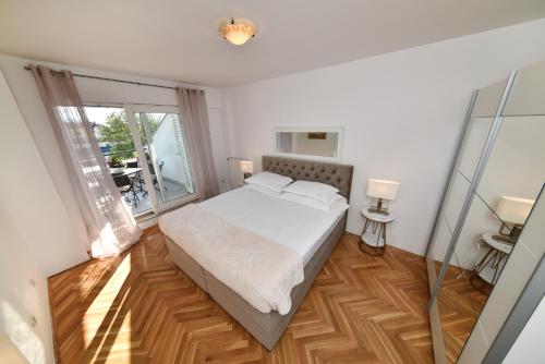 a bedroom with a bed and a large window at APARTMENT MEMORY in Zadar