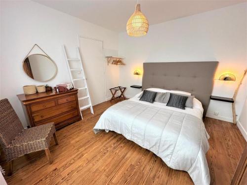 une chambre avec un lit, un miroir et une chaise dans l'établissement Les jardins de Mimizan, à Mimizan