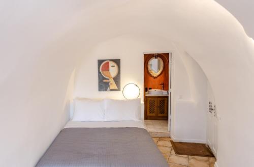 a bedroom with a bed in a white room at Villa Ambrosia in Oia