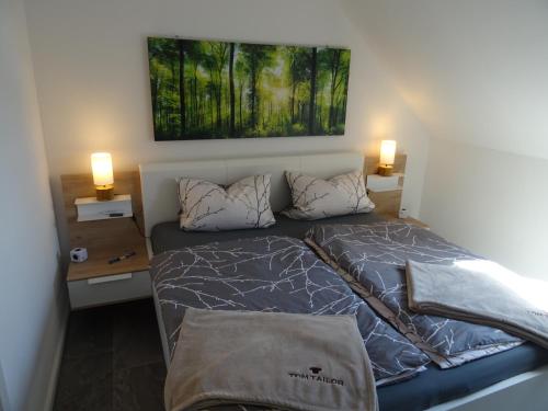 a bed in a bedroom with two lamps on the wall at Sammy's FeWo in Hahnenklee-Bockswiese