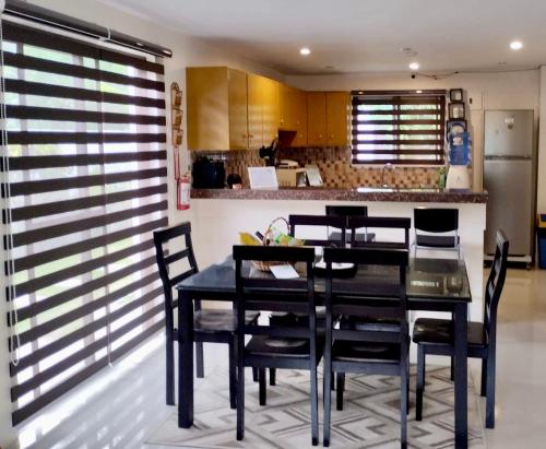 a dining room with a black table and chairs at Casa LeoMa in Cavite