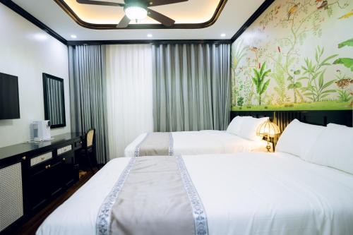 a hotel room with two beds and a wall mural at Thanh Cong Hotel Ha Long in Ha Long