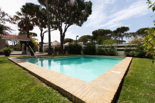 una piscina con un camino de madera alrededor en Villa América Chalet Independiente con Piscina en Urbanización Roche Conil Cádiz Andalucía España, en Roche