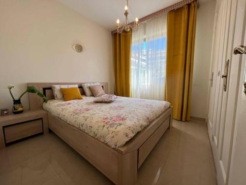 une chambre avec un grand lit et une fenêtre dans l'établissement Résidence Côte d'Azur Cannes, à Cannes