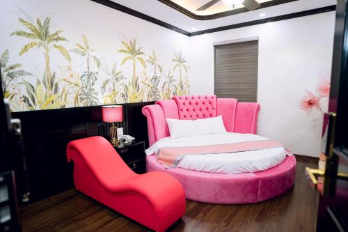 a bedroom with a pink bed and a chair at Thanh Cong Hotel Ha Long in Ha Long