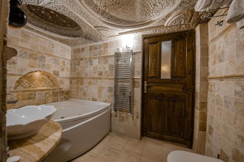 a bathroom with a tub and a sink at Konak Bezirhane Cave Otel in Urgup