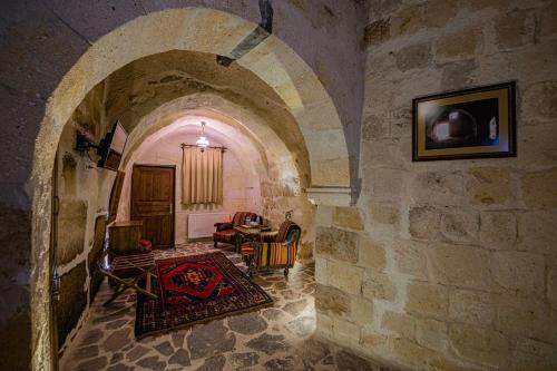 a room with an archway with a table and chairs at Konak Bezirhane Cave Otel in Urgup