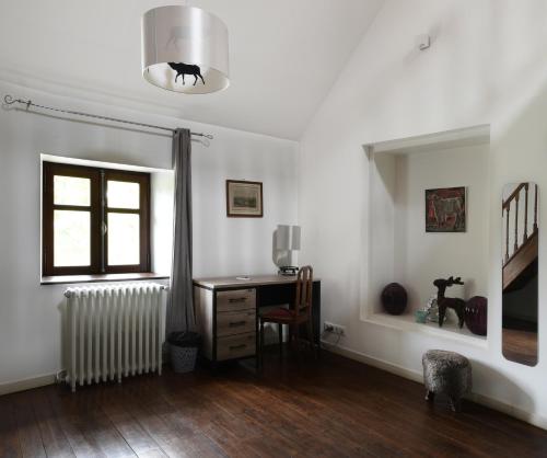 a room with a desk and a window and a radiator at Château - Hôtel Le Sallay in Magny-Cours