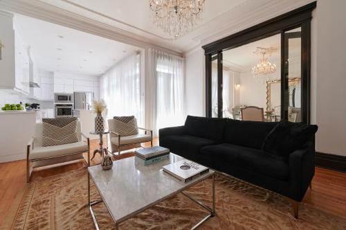 a living room with a black couch and a table at Villa Dante By Denstays in Montréal