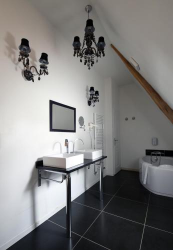a white bathroom with a sink and a tub at Château - Hôtel Le Sallay in Magny-Cours