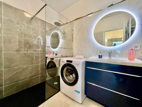 une salle de bain avec une machine à laver et un lavabo dans l'établissement Résidence Côte d'Azur Cannes, à Cannes