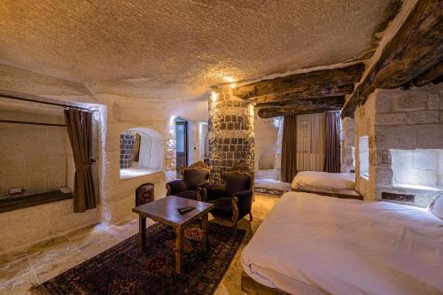 a bedroom with a bed and a table in a room at Konak Bezirhane Cave Otel in Urgup