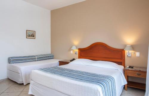 Habitación de hotel con 2 camas y 2 lámparas en Hotel Mercedes en Ilhabela