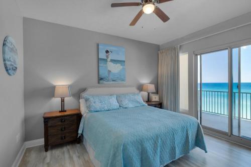 Schlafzimmer mit einem Bett mit blauer Tagesdecke in der Unterkunft Treasure Island 0408 in Panama City Beach
