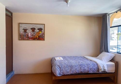 a bedroom with a bed and a picture on the wall at Homestay Pachamama in Cabanaconde