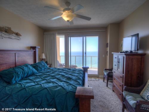 een slaapkamer met een bed, een televisie en een raam bij Treasure Island 0706 in Panama City Beach