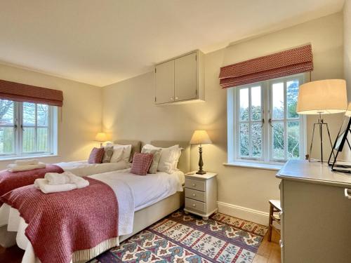 a bedroom with two beds and two windows at Beaufort Barn by Inspire Stays in Bignor