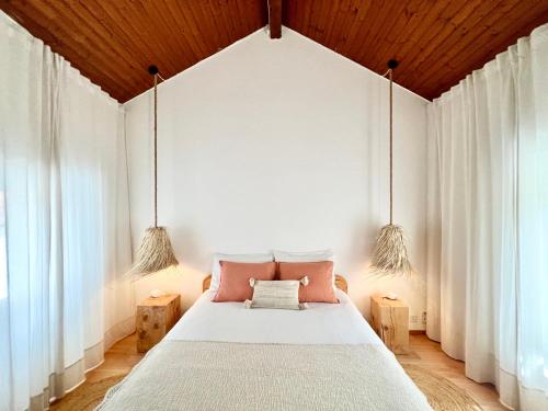 1 dormitorio con 1 cama con 2 luces colgantes en Boho Lake House - Private Beach 600m from the property - Free Parking - Home Cinema Room en Vira