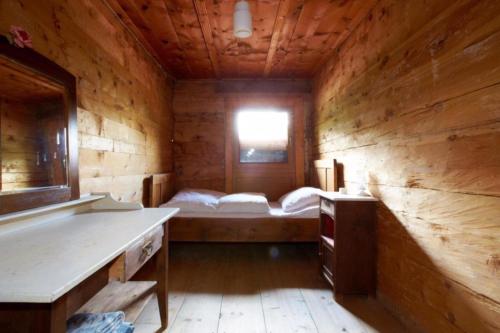 a room with a bed in a wooden cabin at Grawandhütte in Ginzling