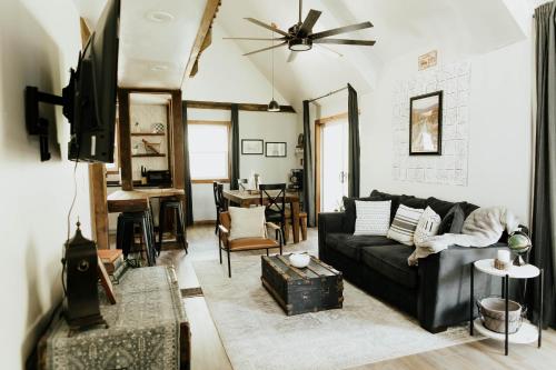 a living room with a black couch and a tv at NO CHORES Cozy Family Cabin 2 minutes to town-Spacious Double Decks with Forest view! in Nashville