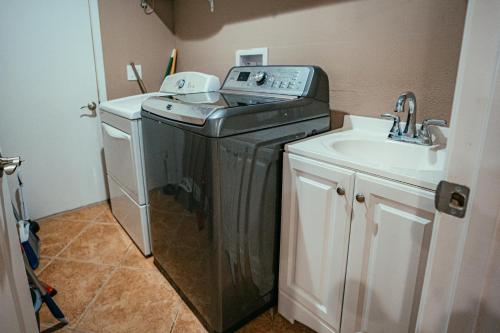 a small laundry room with a washer and a sink at Fitzgerald House in Tampa